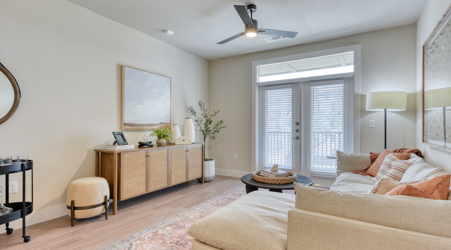 living room with sofa, coffee table, & view to the patio